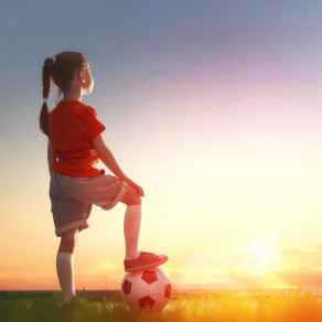 Cute little child dreams of becoming a soccer player. Girl plays football.